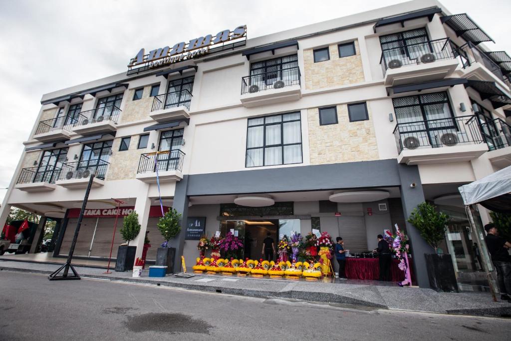 a large white building with a store on the street at Amamas Boutique Hotel Kuching in Kuching