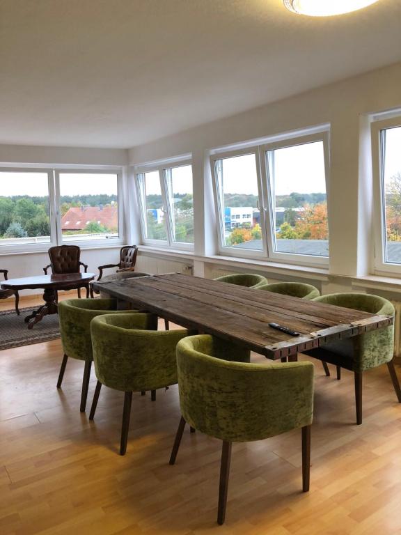 a dining room with a wooden table and green chairs at Big Space-Loft in Hannover