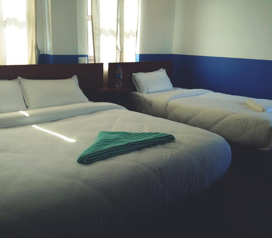 邦帝培的住宿－Good Hotel，客房内的两张床,上面有绿毛巾