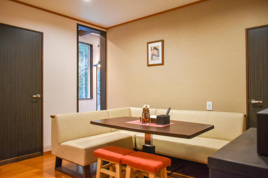 uma sala de estar com um sofá e uma mesa em Mojo Lodge Hakuba em Hakuba