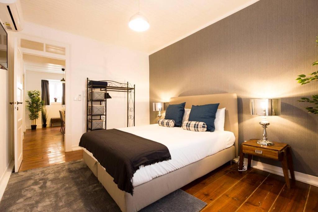 1 dormitorio con 1 cama grande con almohadas azules en Ola Lisbon - Terrace Castelo VI, en Lisboa