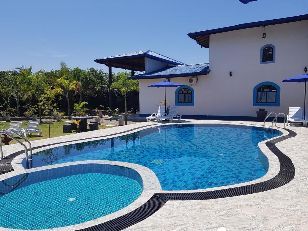 une grande piscine en face d'une maison dans l'établissement Dhammika Magic Palace, à Wadduwa