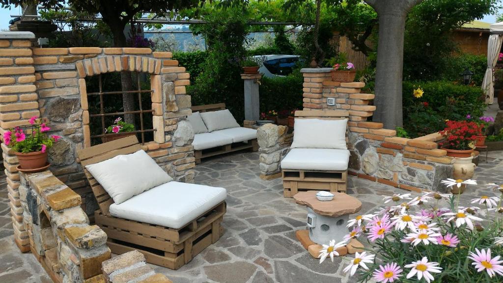 a patio with two chairs and a stone fireplace at Bed and Breakfast Val Di Lupa in Castellina Marittima