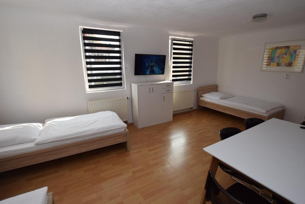 ein Wohnzimmer mit 2 Betten und 2 Fenstern in der Unterkunft AB Apartment Objekt 114 in Fellbach
