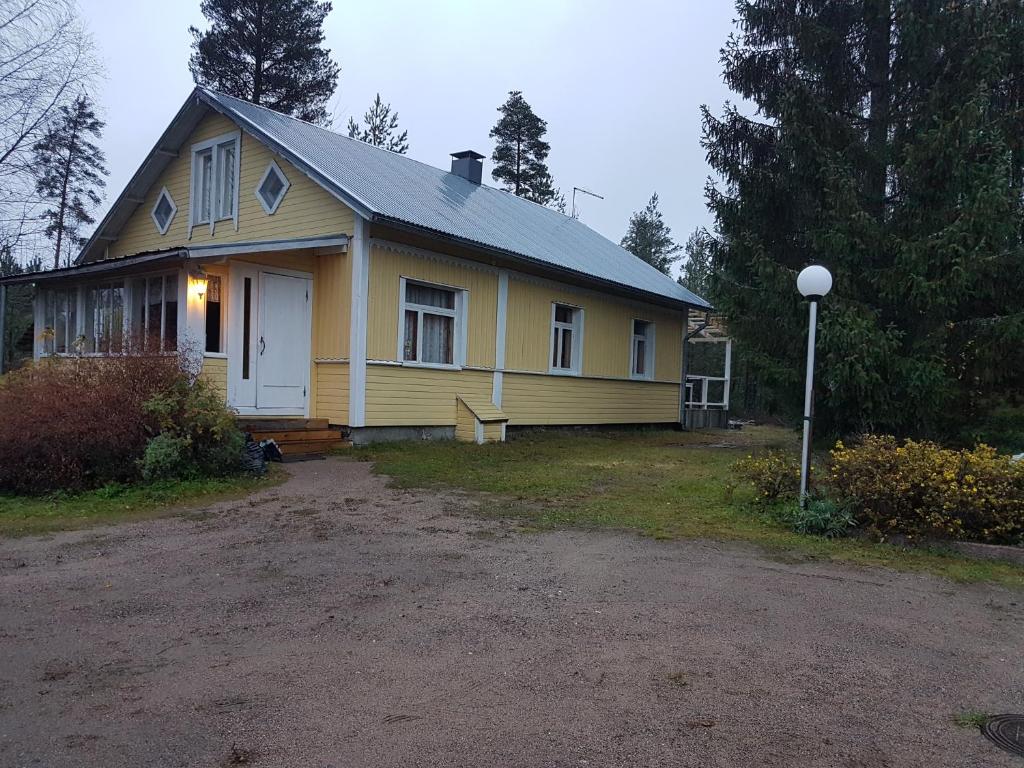 żółty dom z gankiem i podjazdem w obiekcie Miekkala Lomatalo w mieście Ilottula