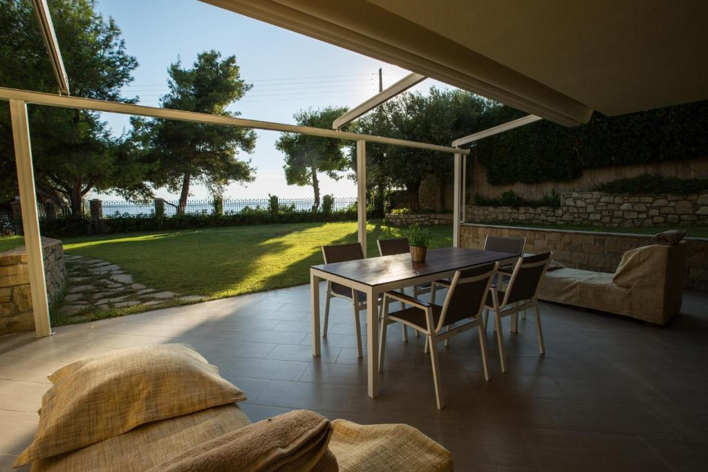un patio con tavolo, sedie e divano di Moriel Seaside Homes Suites a Elia