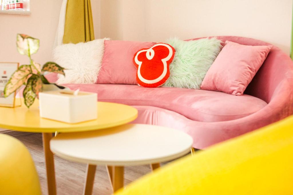a pink couch in a living room with two tables at Chengdu Dujiangyan·DuJiangYan· Locals Apartment 00171880 in Zhongxing
