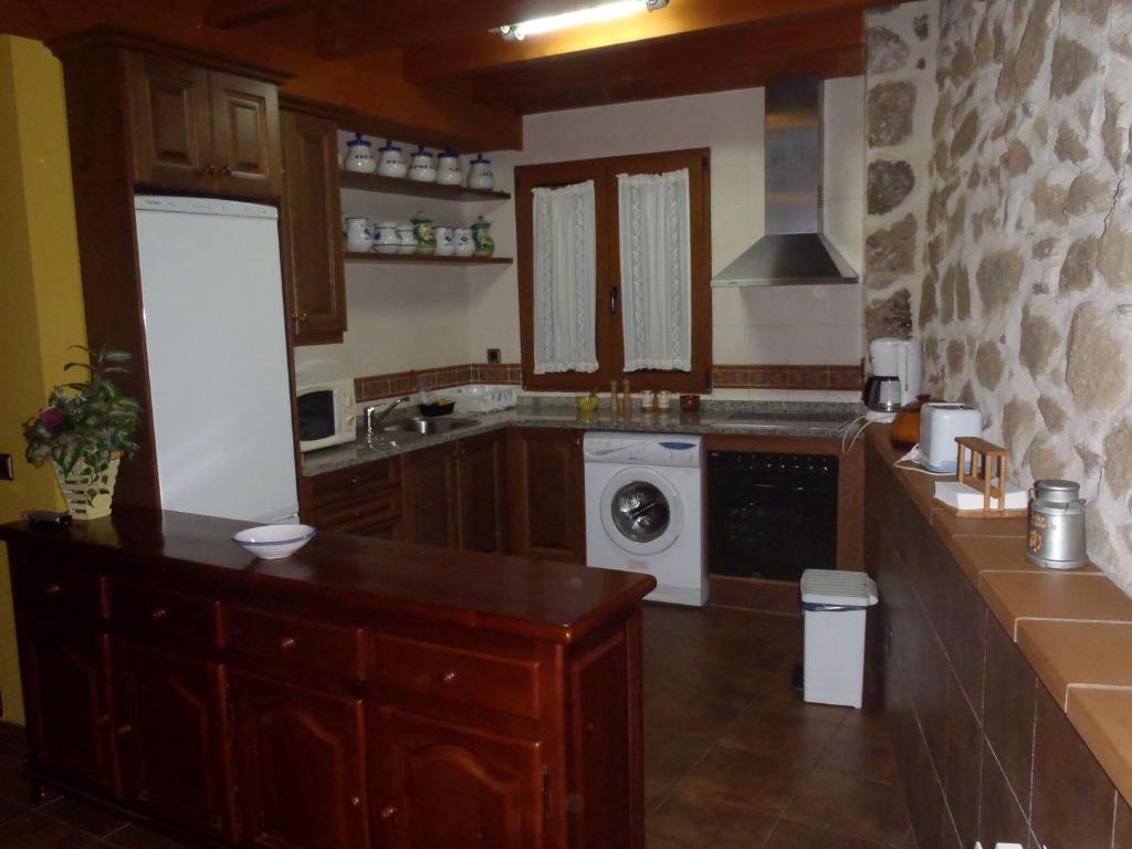 オヨス・デル・エスピーノにあるCasa Rural Tío Carlillosのキッチン(シンク、洗濯機付)