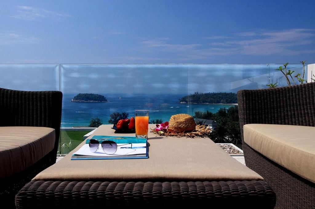 a table with a plate of food and glasses on it at The heights ocean views 2 bedrooms in Kata Beach