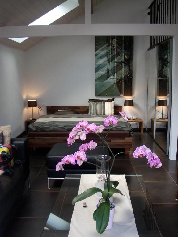 a living room with a table with pink flowers on it at Lodge & lake in Buchillon