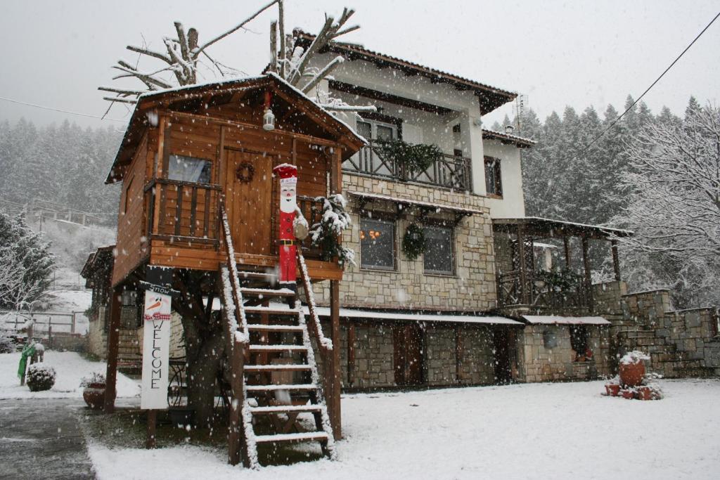 une cabane dans les arbres dans la neige devant une maison dans l'établissement Villa Filokosta, à Pertouli