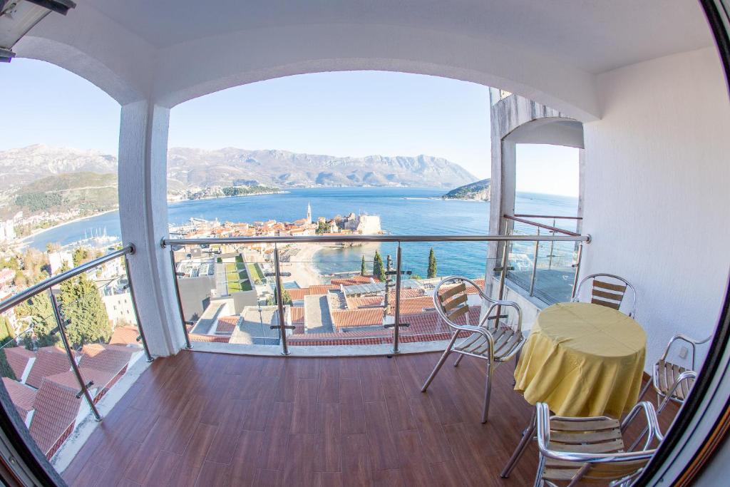 einen Balkon mit einem Tisch und Stühlen sowie Meerblick in der Unterkunft Lux Panoramic Apartment in Budva