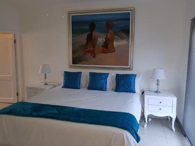 een slaapkamer met een groot bed met blauwe kussens bij Villa COCONUT GROVE in Ramsgate