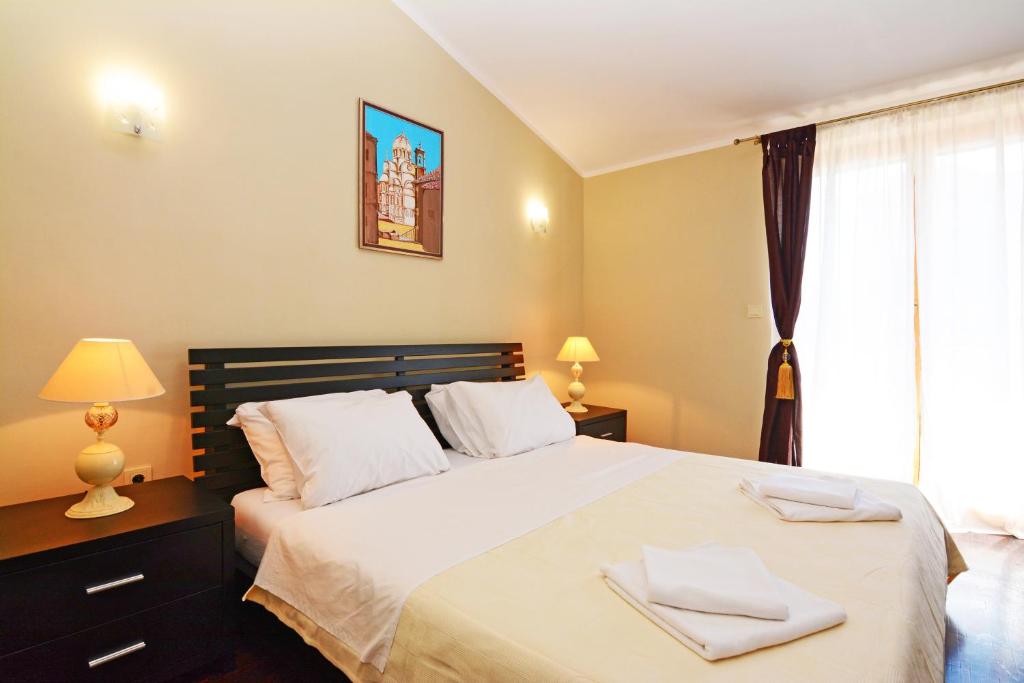 a bedroom with a large bed with two towels on it at Luxury Room Uzorita B&B in Šibenik