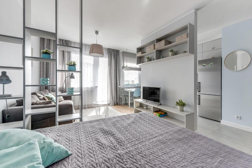 グダニスクにあるGdańsk Comfort Apartments Awiatorのベッドルーム1室(ベッド1台付)、リビングルームが備わります。