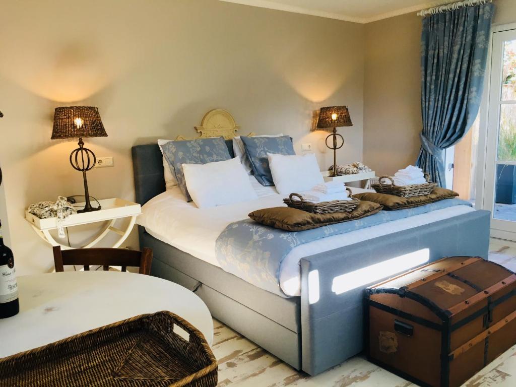 a bedroom with a large bed with two lamps on it at De Vijverkamer-----privé diner op de kamer mogelijk!! in Hoogeveen