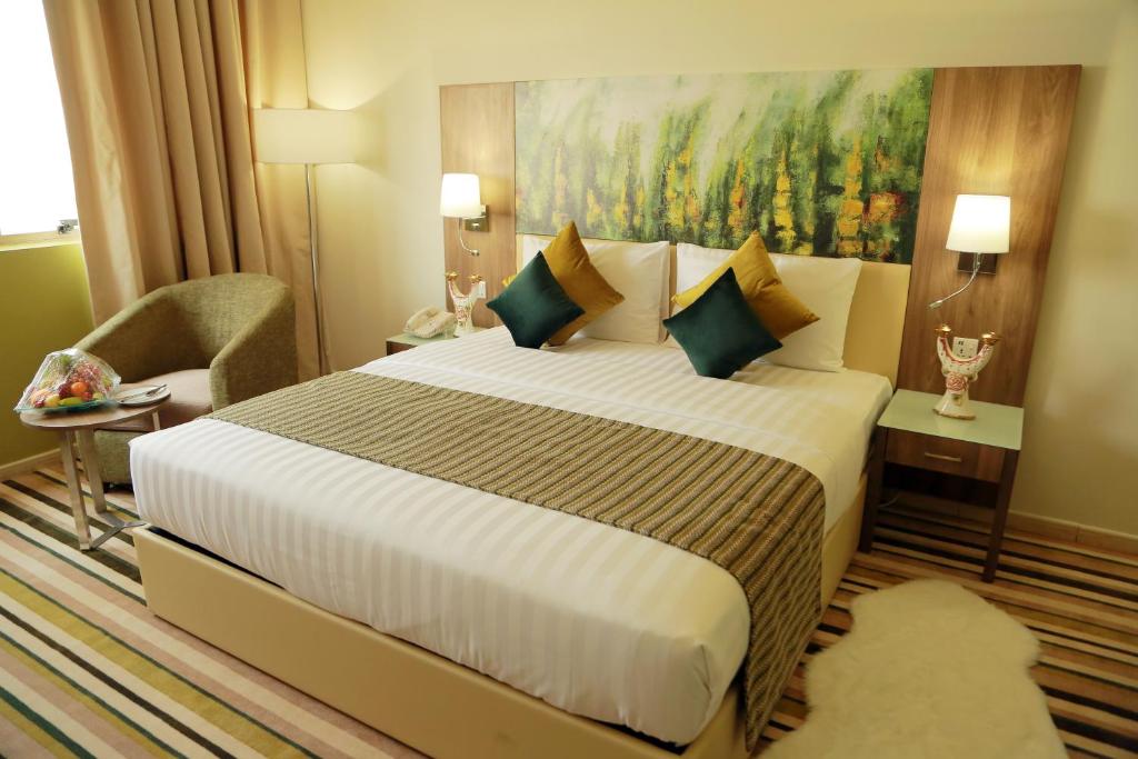 a hotel room with a bed and a painting at Royal View Hotel in Ras al Khaimah