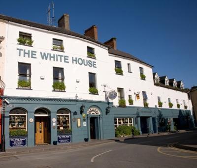 a white building with a white house on a street at The White House in Kinsale