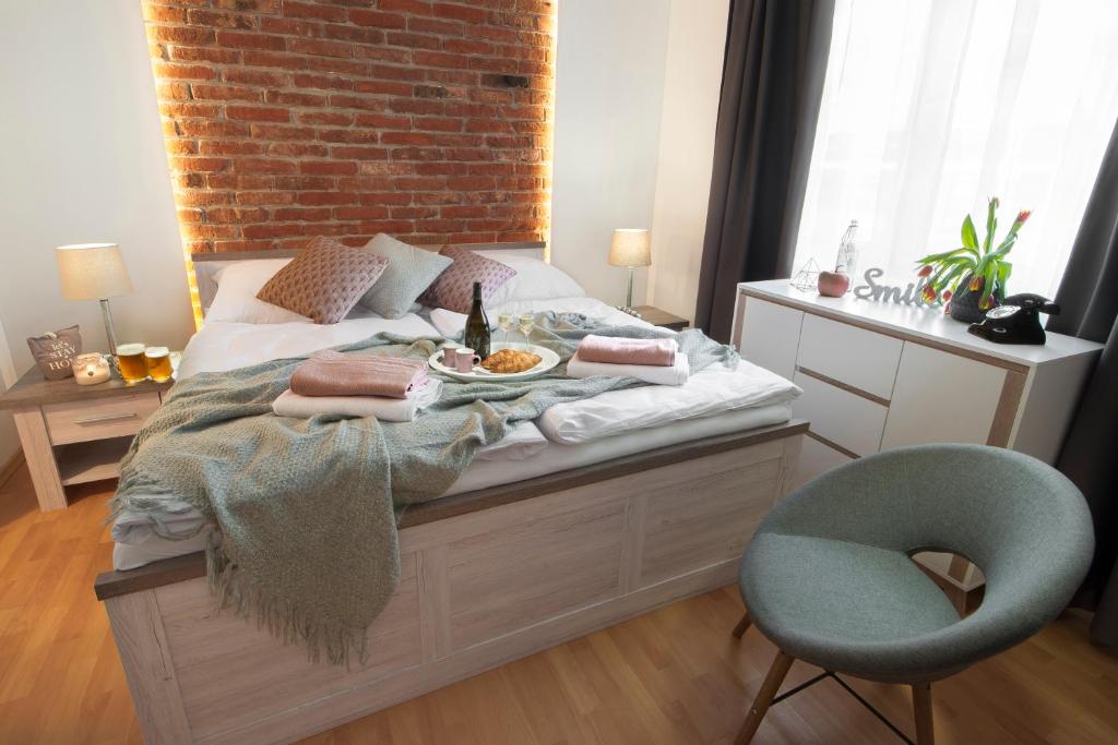 a bed with a plate of food and a chair at Penzión Dobré Časy in Poprad
