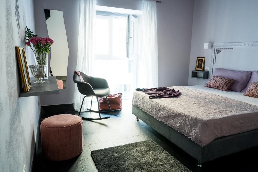 una camera con un letto e una sedia e una finestra di 5 Terre Inn Affittacamere a La Spezia