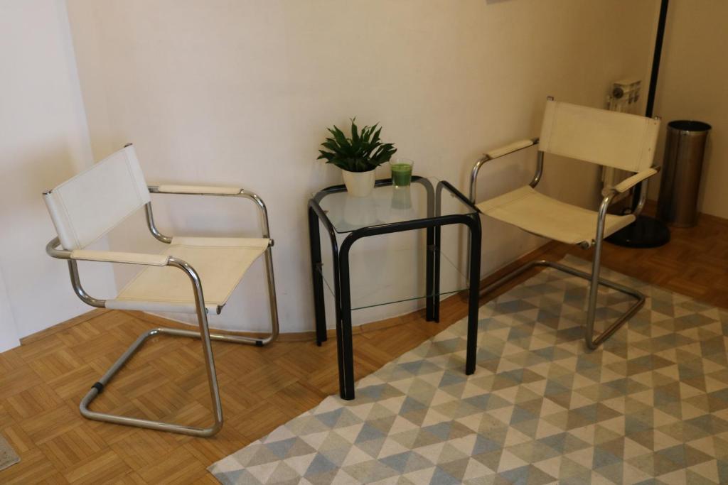 dwa krzesła i stół z rośliną w obiekcie Rooms Vukovarska w Zagrzebiu