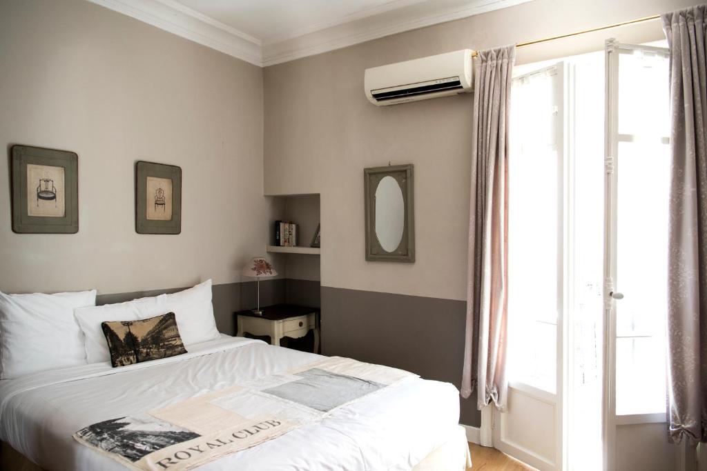a bedroom with a white bed and a window at Hotel Villa Rivoli in Nice