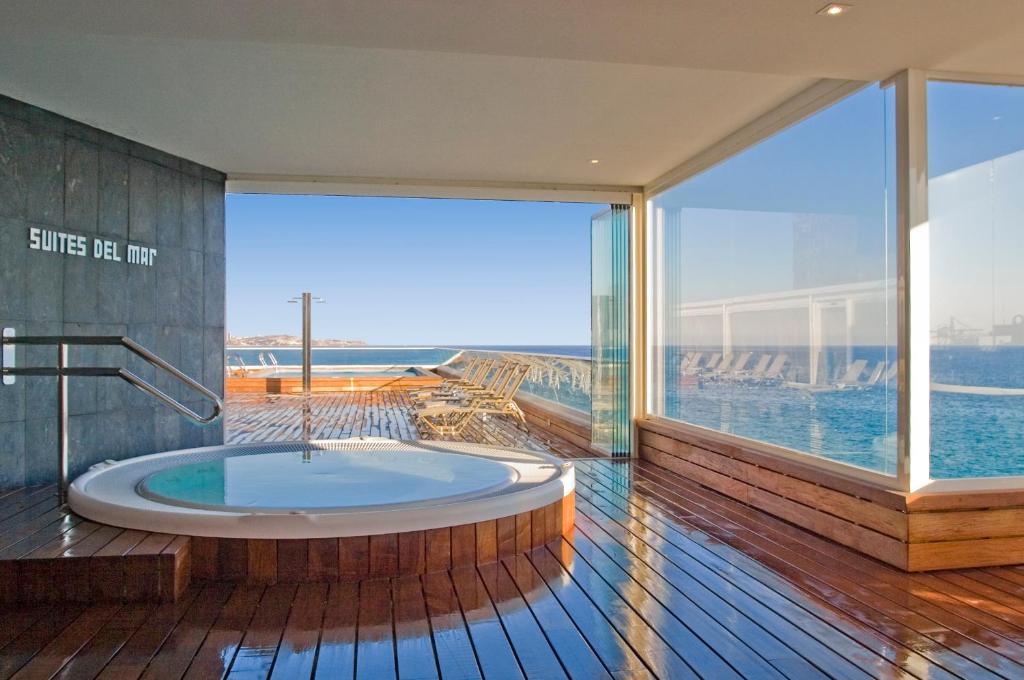 a hot tub in a room with a large window at Suites del Mar by Melia in Alicante