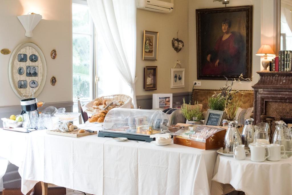 a table with white clothed tables with food on it at Hotel Villa Rivoli in Nice