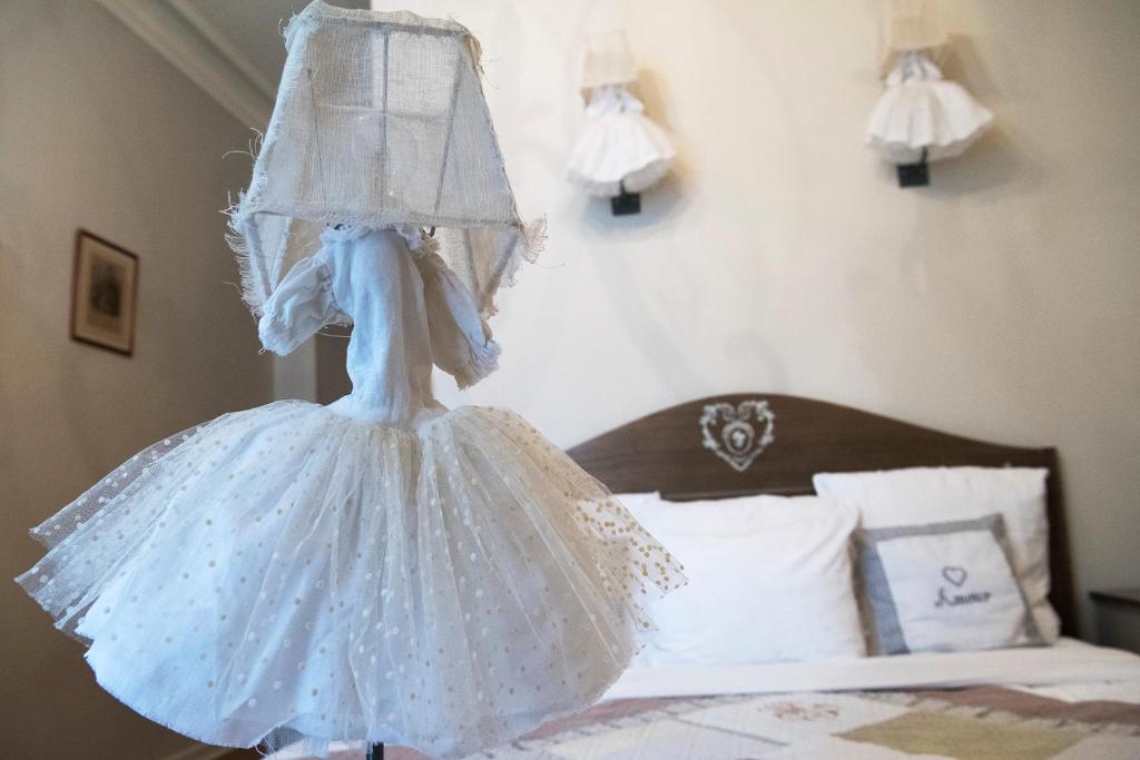 a wedding dress is hanging on a bed at Hotel Villa Rivoli in Nice