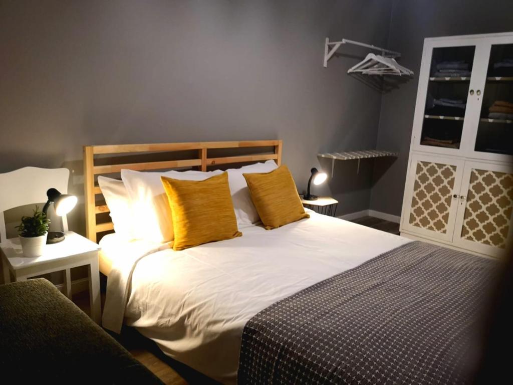 フンシャルにあるApartment Madeira Happinessのベッドルーム1室(大型ベッド1台、黄色い枕付)