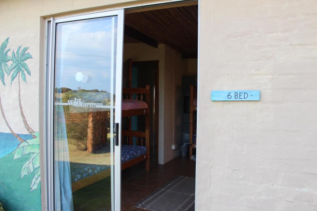 a glass door with a sign that reads at The Wild Farm Backpackers in Wilderness