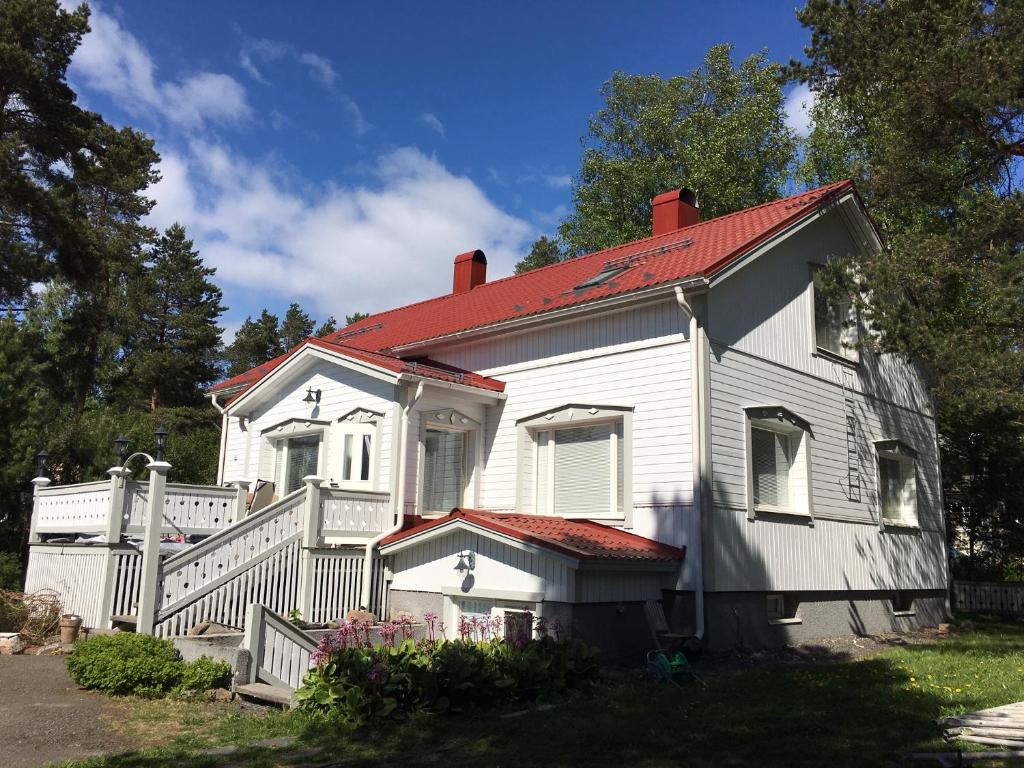 une ancienne maison blanche avec un toit rouge dans l'établissement Yrjänäntie Home Apartment, à Oulu