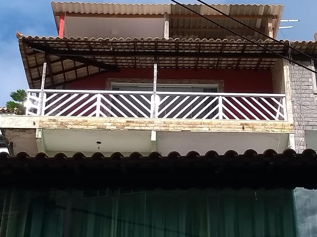 un edificio con un balcón blanco en la parte superior. en Casa do ph1, en Arraial do Cabo