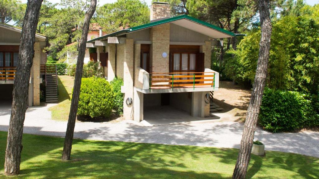a small house with a porch and a balcony at Hotel President in Lignano Sabbiadoro