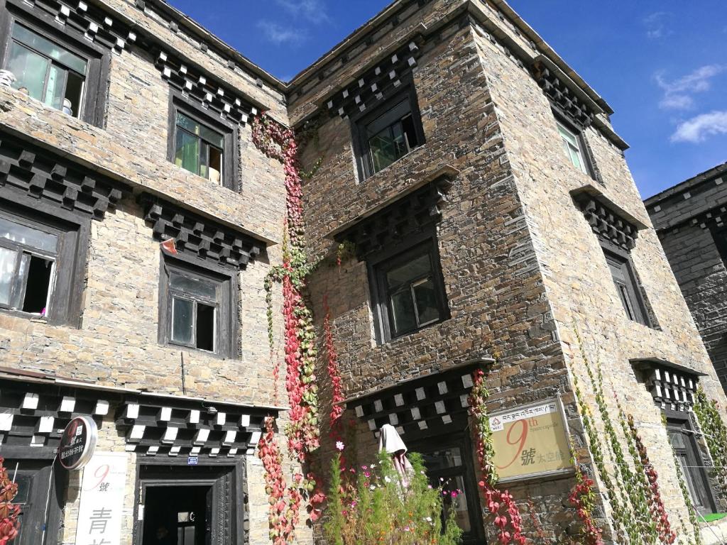 um edifício de tijolos com flores a crescer nele em No.9 Space Capsule Youth Hostel em Daocheng