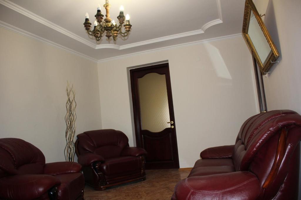uma sala de estar com duas cadeiras e um lustre em Chekin Imereti em Kutaisi