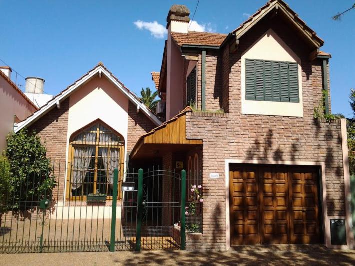 a brick house with a gate and a garage at Bed & breakfast Familia San Martín in Vicente López