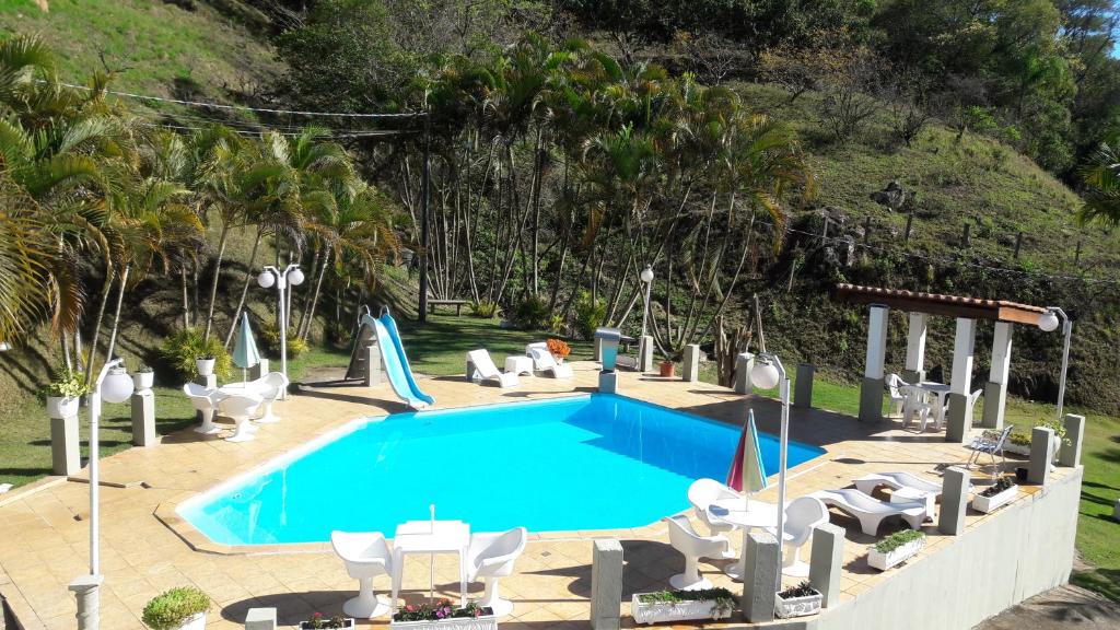 uma piscina com espreguiçadeiras e uma piscina em Pousada Cachoeira em Serra Negra
