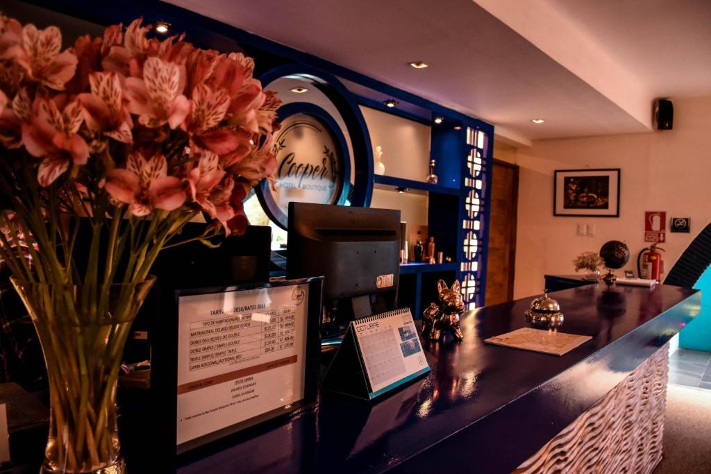 a counter with a vase of flowers on it at Cooper Hotel Boutique in Cusco