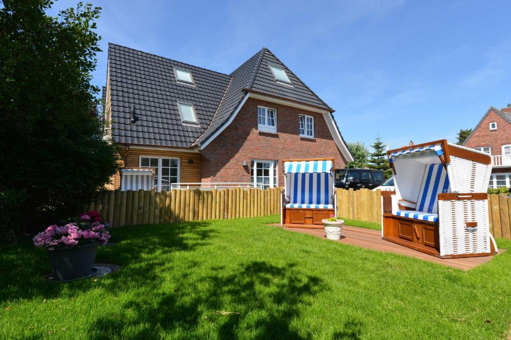 a yard with two chairs and a house at Strandgut 3 in Westerland