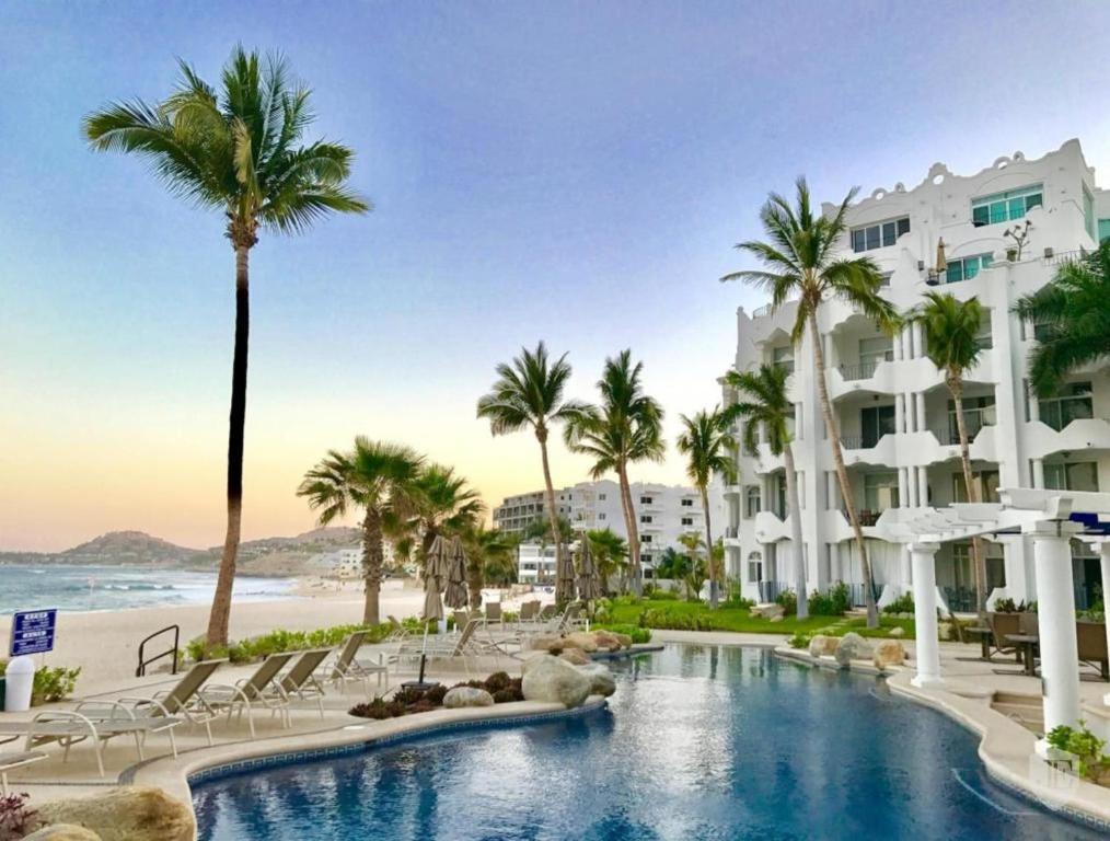 um resort com piscina e palmeiras em Beach Front Mykonos em San José del Cabo