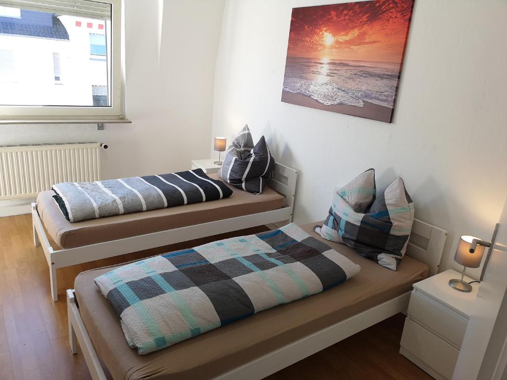 a bedroom with two beds and a picture on the wall at Lüdenscheid-Ferienwohnung de Betzler Weh29-100 in Lüdenscheid