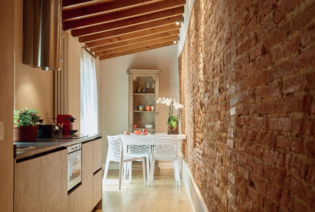 uma cozinha com uma mesa branca e uma parede de tijolos em Pergola35 em Florença
