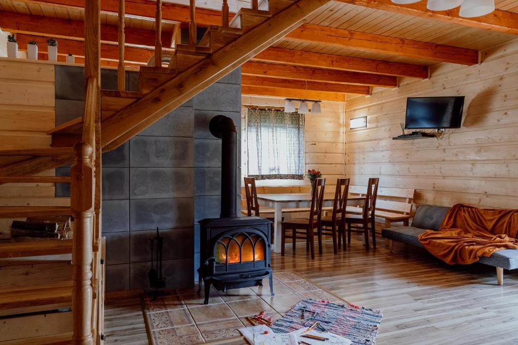 una sala de estar con estufa de leña en una cabaña en Domek na Zagrodzie, en Rycerka Górna