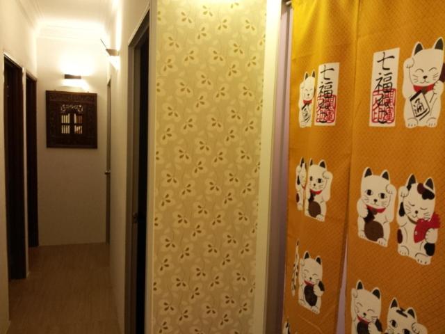 un pasillo con una pared con pegatinas de gatos. en Fastbook Bendera Home 8 & 10pax, en Ayer Itam