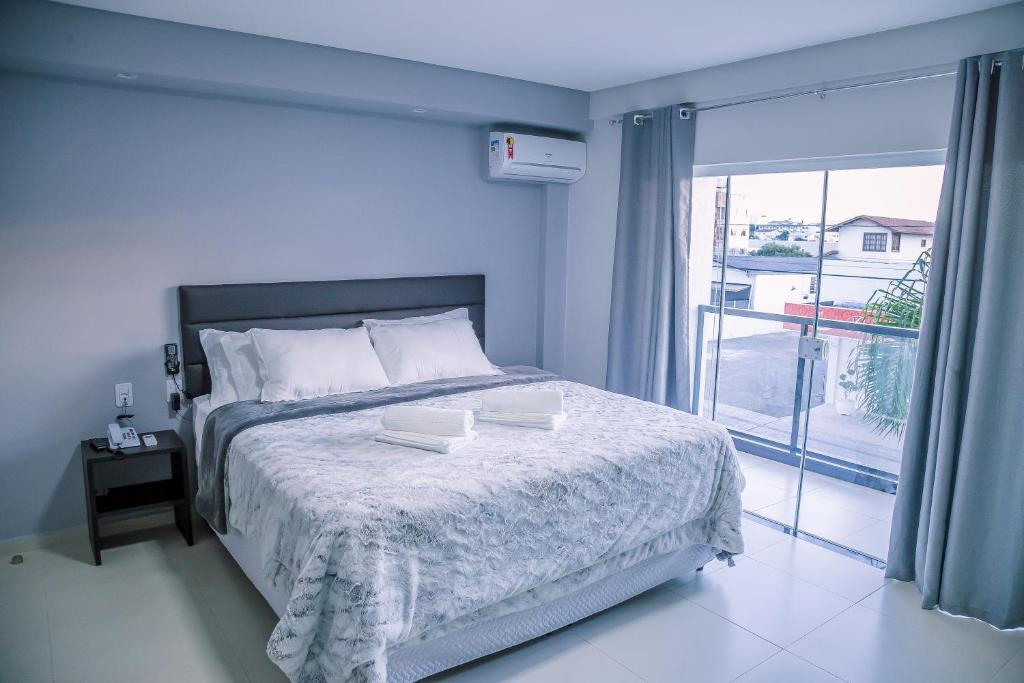 Un dormitorio con una cama con dos libros. en Hotel Prime Executive, en Campos Novos