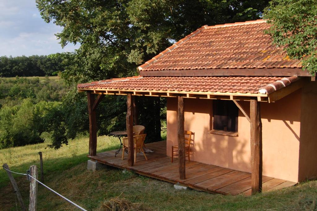 a small house with a deck in a field at Chalet à Bazian in Bazian
