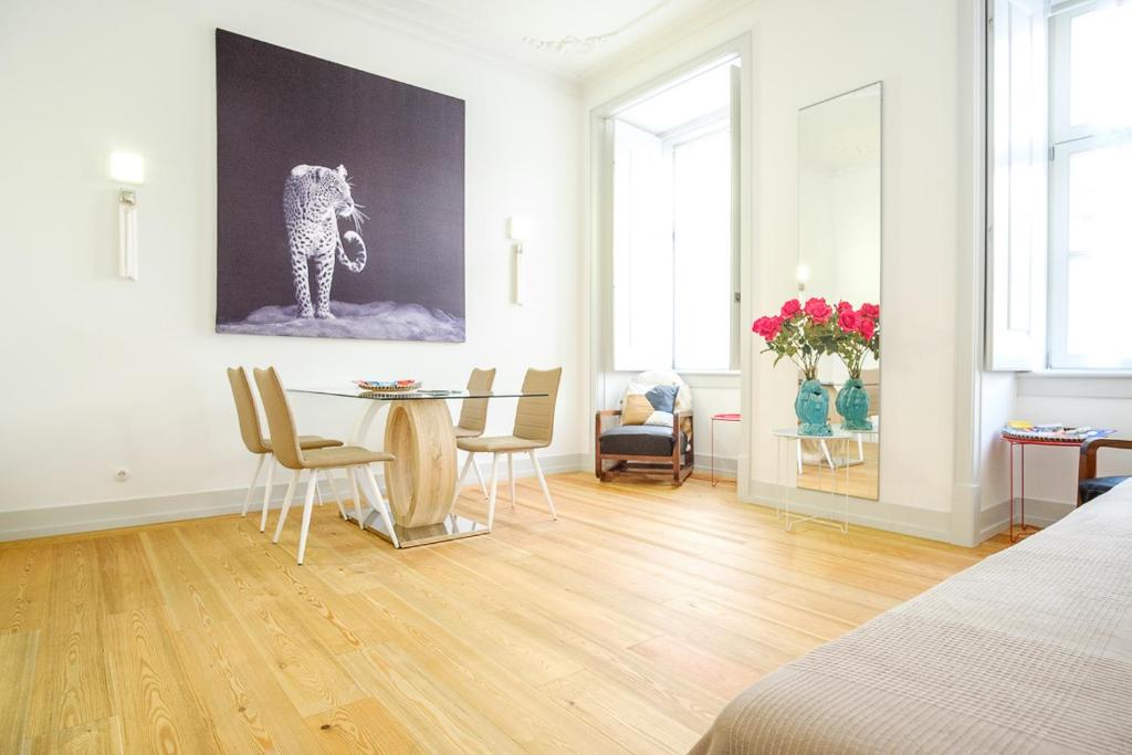 - un salon avec une table, des chaises et un tableau dans l'établissement Superb Apartment in historical Centre, à Lisbonne
