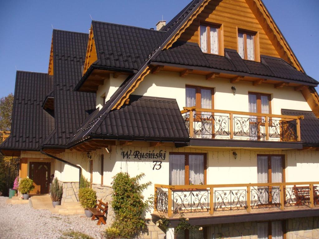 une grande maison avec un toit noir dans l'établissement Willa Floryn, à Bukowina Tatrzańska