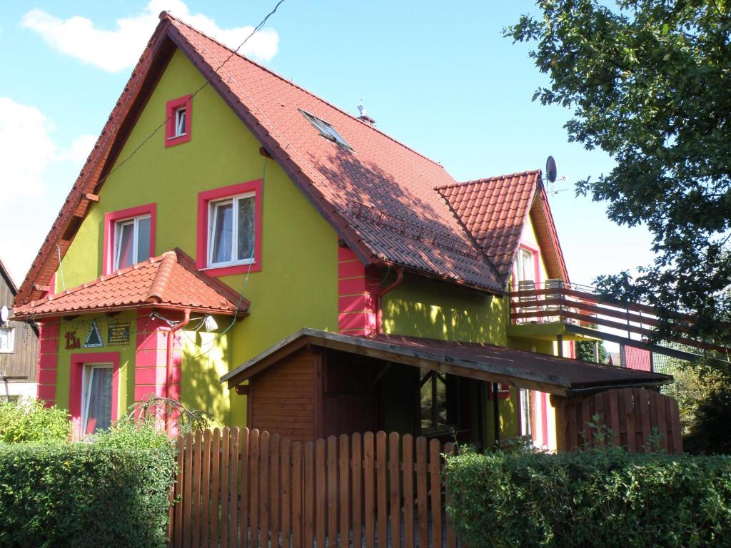zielony i czerwony dom z drewnianym płotem w obiekcie Szkolne Schronisko Młodzieżowe Wojtek w Jeleniej Górze